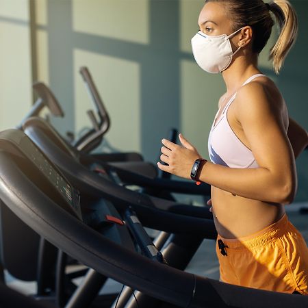 voco Dubai, an IHG Hotel Esterno foto A woman wearing a face mask while exercising on a treadmill