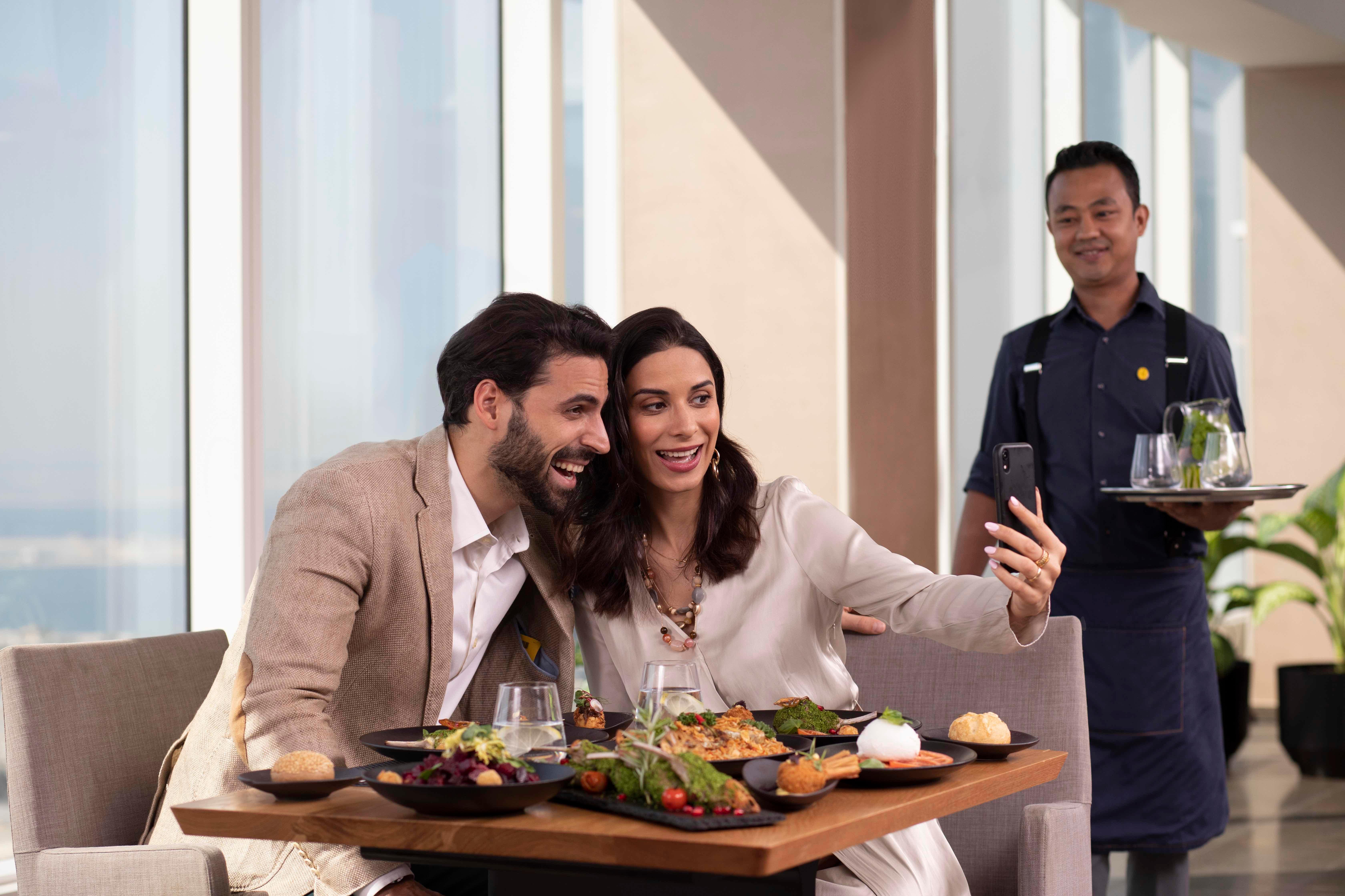 voco Dubai, an IHG Hotel Esterno foto A waiter serving a couple
