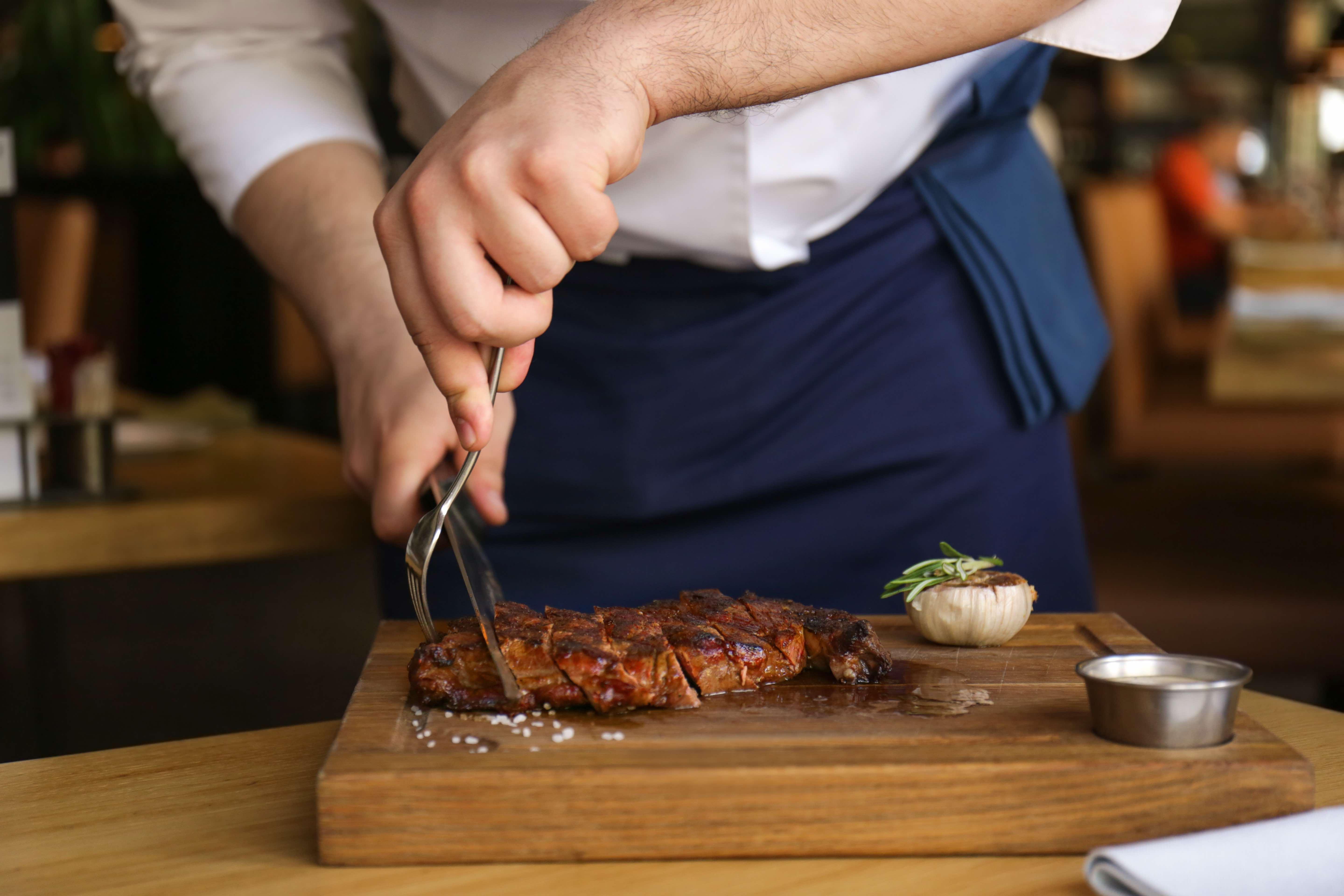 voco Dubai, an IHG Hotel Esterno foto A chef cutting a steak
