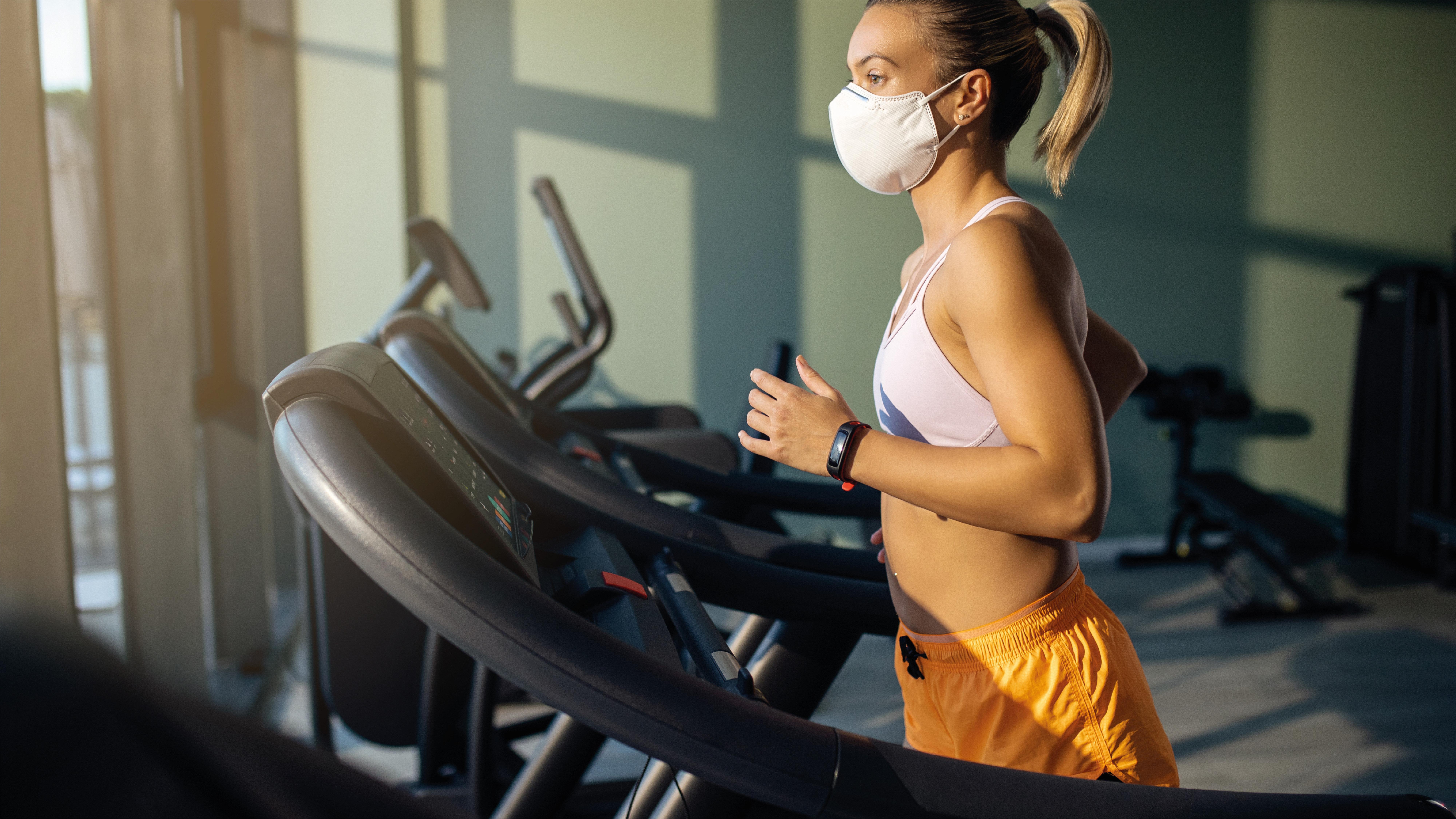 voco Dubai, an IHG Hotel Esterno foto A woman wearing a face mask while exercising on a treadmill