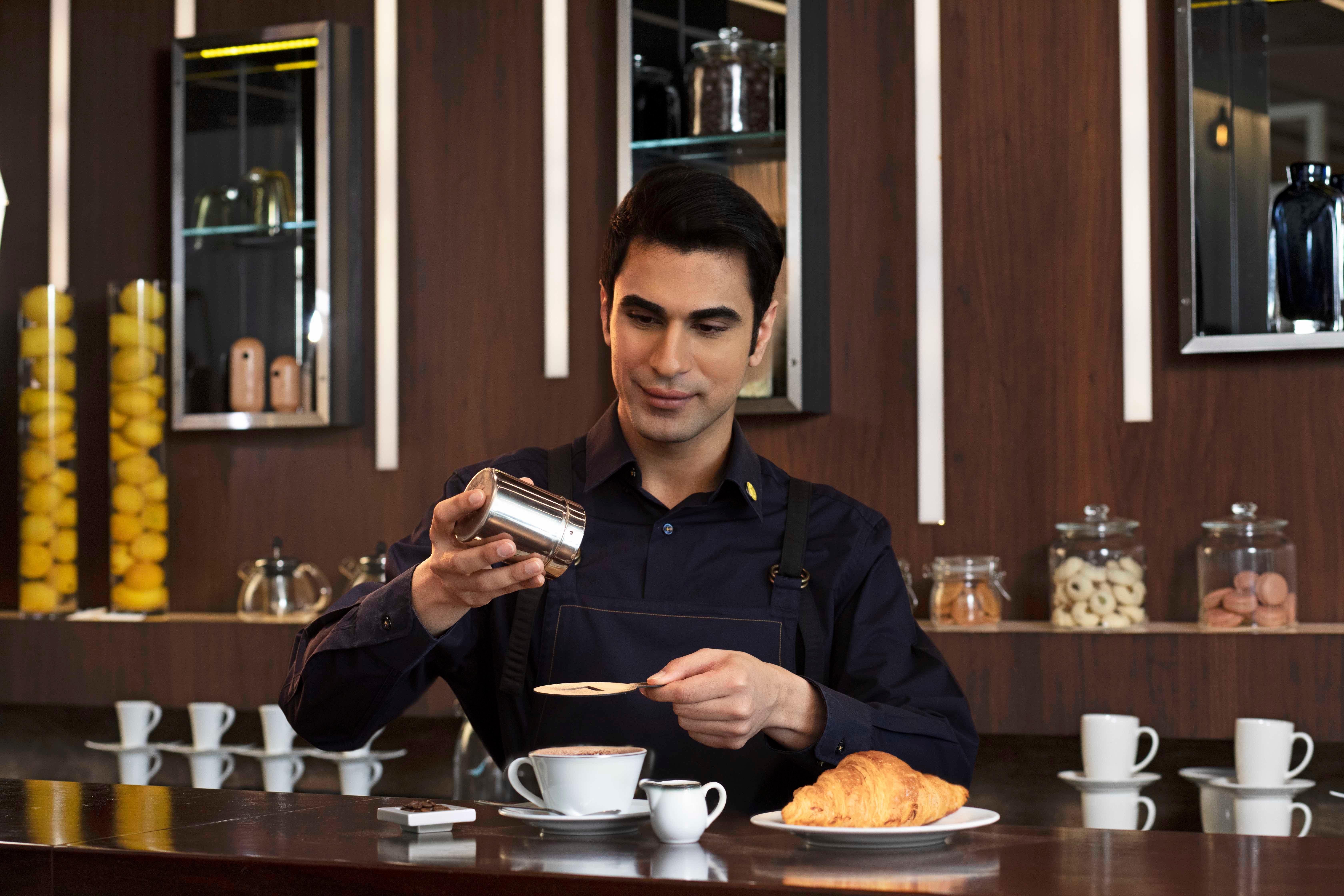 voco Dubai, an IHG Hotel Esterno foto A barista at work
