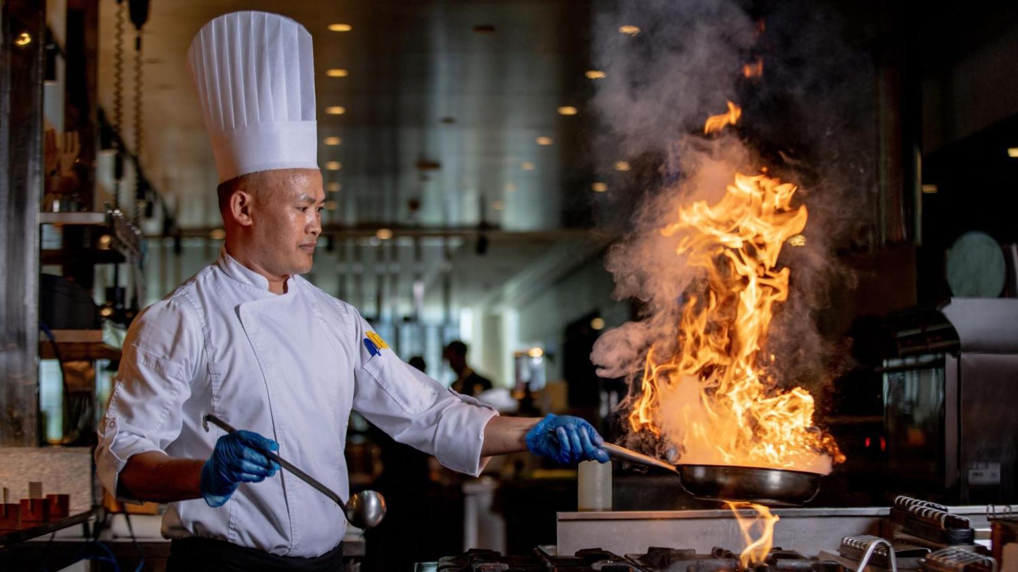 voco Dubai, an IHG Hotel Esterno foto A chef cooking with a flaming wok