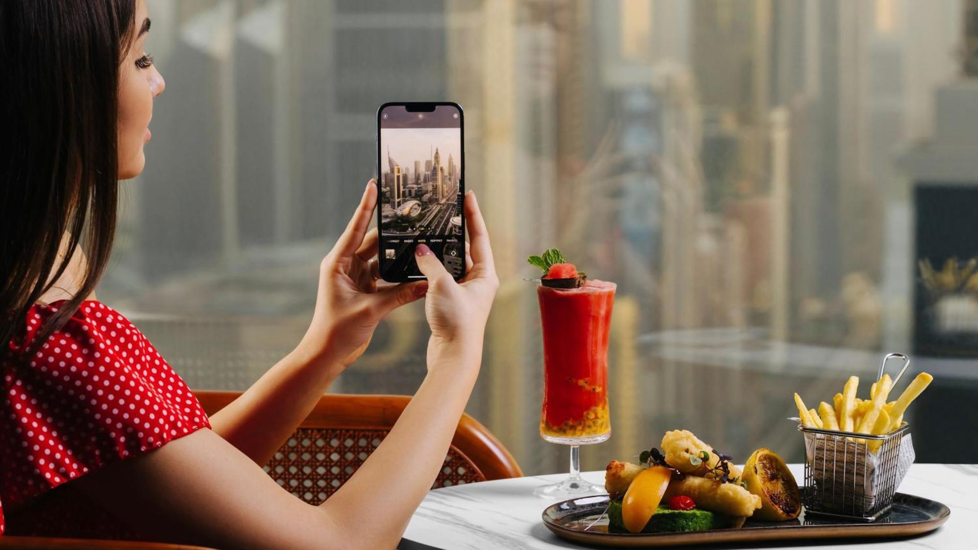 voco Dubai, an IHG Hotel Esterno foto A woman taking a photo with a smartphone
